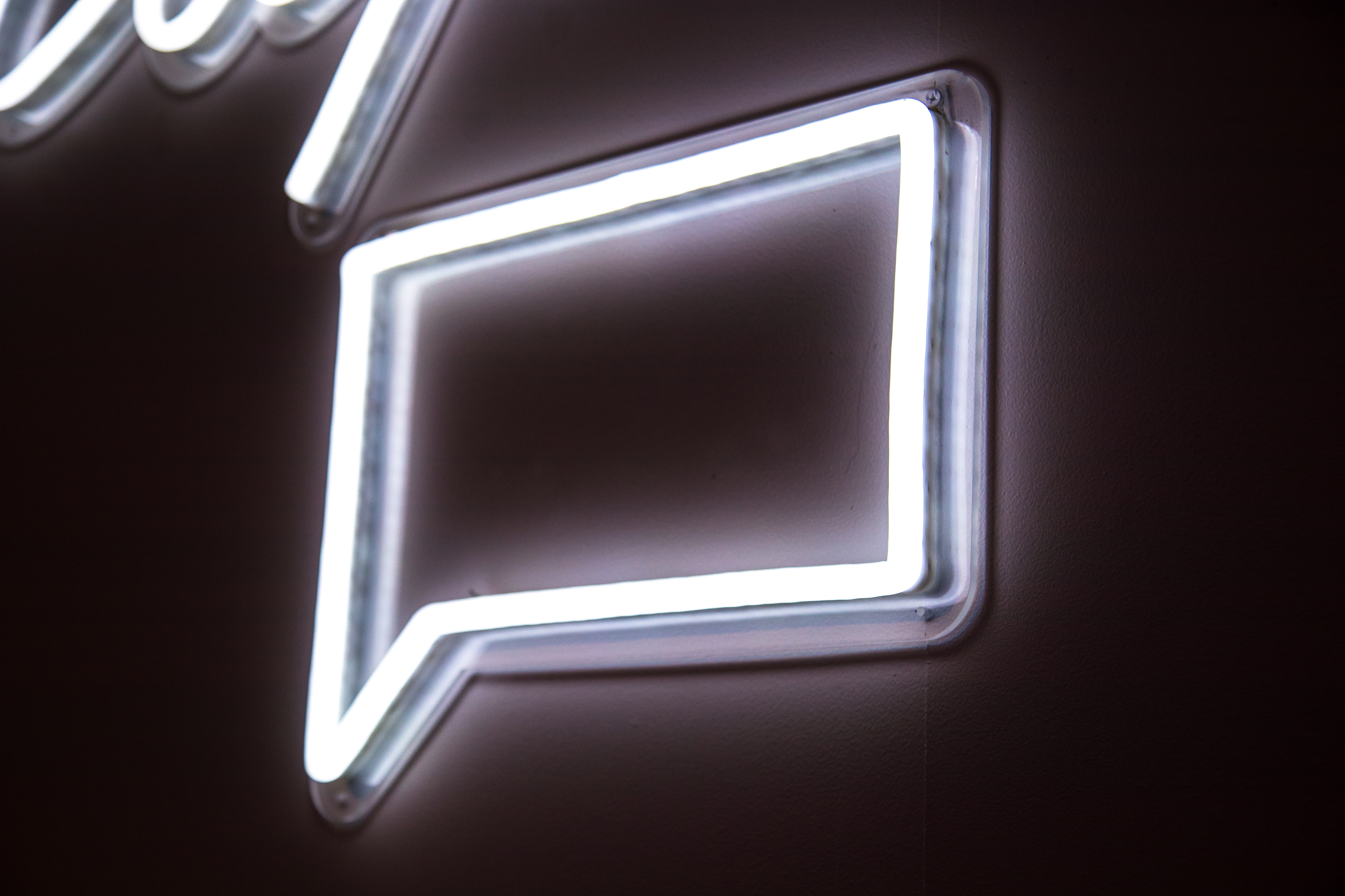 A white neon sign in the shape of a text bubble